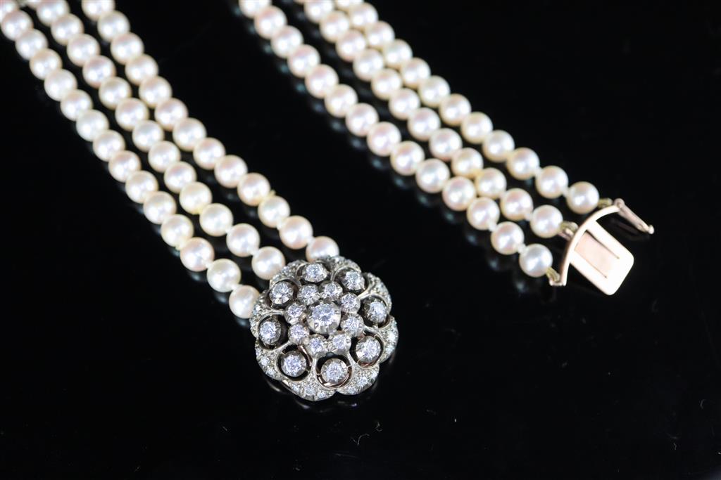 A modern triple row cultured pearl necklace with an earlier Victorian gold, silver and diamond cluster set clasp,